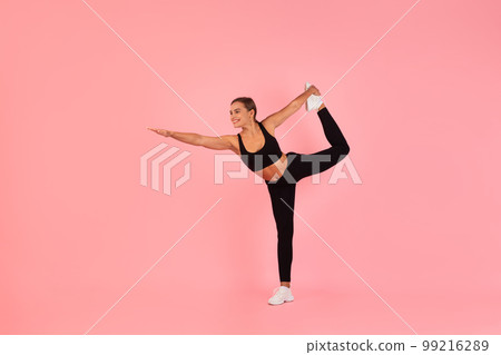 Sporty Young Woman Practicing Balance Exercise While Training Over Pink Background 99216289