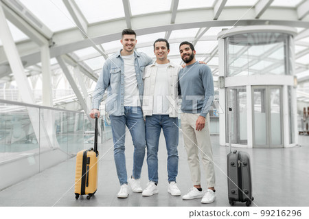 Three Male Tourists Standing With Suitcases Posing In Airport Indoors 99216296