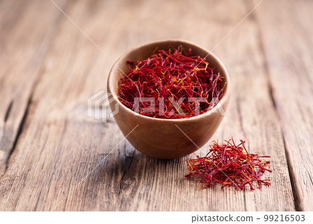 Saffron threads on wooden background 99216503