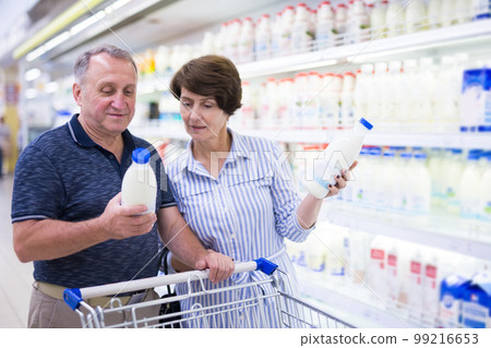 Mature cElderly couple buys milk in dairy section of a supermarket ouple husband and wife choose milk in supermarket Mature cElderly couple buys milk in dairy section of a supermarket ouple husband and wife choose milk in supermarket 99216653