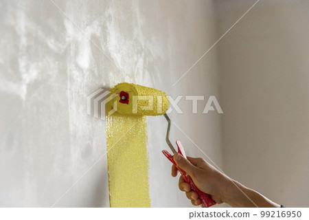 Workman painting the wall in yellow. Workman painting the wall in yellow. 99216950