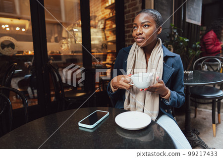 Stylish young african woman at cafe having coffee 99217433