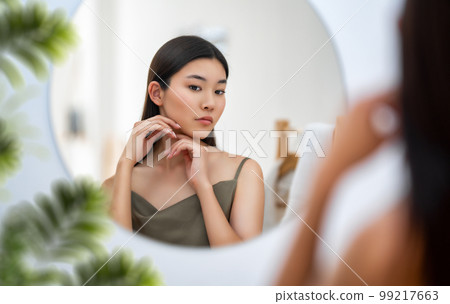 woman looking at mirror 99217663