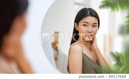 woman looking at mirror 99217689