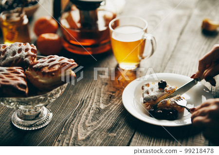 Close up image of a woman eating cherry pastries with fork and knif in cafe Close up image of a woman eating cherry pastries with fork and knif in cafe 99218478