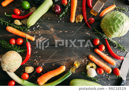 Assorted raw organic vegetables on dark wooden background with copy space Assorted raw organic vegetables on dark wooden background with copy space 99218529