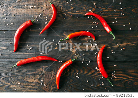 Red hot chili peppeprs on dark wooden background Red hot chili peppeprs on dark wooden background 99218533
