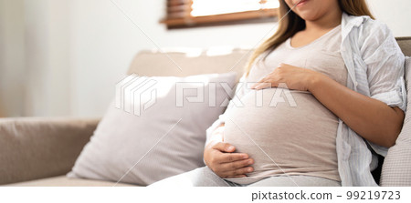 pregnancy, rest, people and expectation concept - close up of happy smiling pregnant woman in and touching her belly at home pregnancy, rest, people and expectation concept - close up of happy smiling pregnant woman in and touching her belly at home 99219723