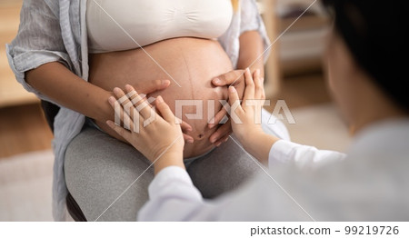 Happy Asian pregnant woman with her doctor in the examination room Happy Asian pregnant woman with her doctor in the examination room 99219726