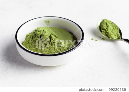 Green superfood powder in white bowl. Wheat grass, barley grass, chlorella, spirulina, maca powder. Green superfood powder in white bowl. Wheat grass, barley grass, chlorella, spirulina, maca powder. 99220386