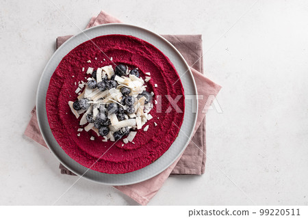 raw vegan beetroot cake decorated with blueberries and coconut chips. 99220511