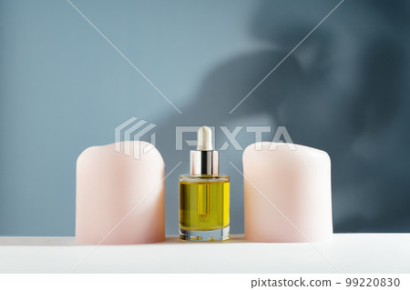 yellow face and hair oil with candles on blue background yellow face and hair oil with candles on blue background 99220830