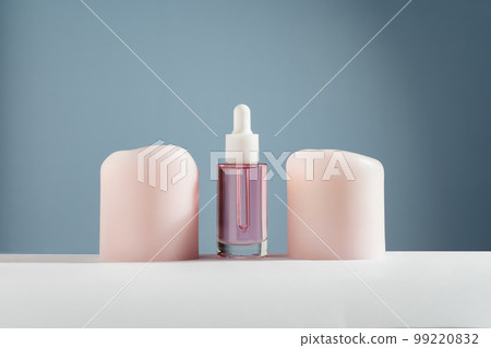 Pink face and hair oil with candles on blue background Pink face and hair oil with candles on blue background 99220832