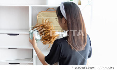 Housewife holding a dusting brush to clean things Pillows, rugs and other things in the living room, Big cleaning, Daily routine ,Removes germs and dirt and deep stains, Clean up on weekends. Housewife holding a dusting brush to clean things Pillows, rugs and other things in the living room, Big cleaning, Daily routine ,Removes germs and dirt and deep stains, Clean up on weekends. 99220965