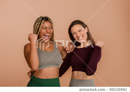 Studio portrait of two young friends in sportive clothes. 99220992