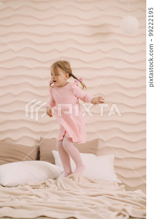 Morning of little girl in a comfortable bedroom. Happy child girl having fun and plays in bed 99222195