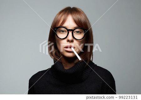 beautiful smoking woman in glasses. girl with cigarette 99223131