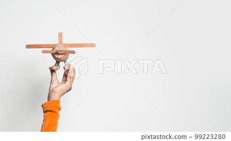 Wooden toy airplane in hand on white background 99223280