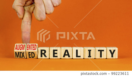 Augmented or mixed reality symbol. Concept words Augmented reality Mixed reality on wooden cubes. Beautiful orange background. Businessman hand. Business augmented or mixed reality concept. Copy space 99223611