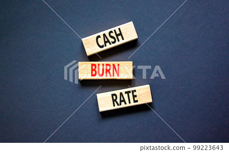 Cash burn rate symbol. Concept words Cash burn rate on wooden blocks on a beautiful black table black background. Business cash burn rate concept. Copy space. 99223643