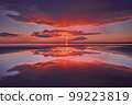 Sun rays and reflection of the sky in the water during a red sunset on the Gulf of Finland of the Baltic Sea. 99223819