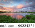 Beginning of summer in countryside after rain with reflection of clouds over river. 99224274