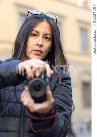 Portrait of photographer woman unfocused background at Florence, Italy. 50mm lens Portrait of photographer woman unfocused background at Florence, Italy. 50mm lens 99224307