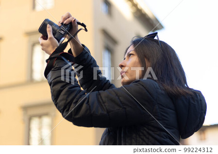 Portrait of photographer woman unfocused background at Florence, Italy. 50mm lens 99224312