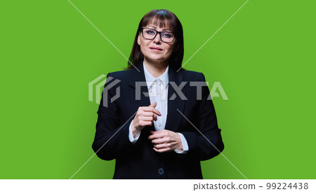 Portrait of smiling mature business woman in a black suit on green background Portrait of smiling mature business woman in a black suit on green background 99224438