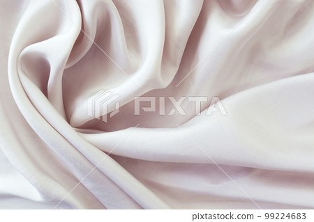 Beige color natural silk draped with folds, top view, fabric texture, pastel shades background 99224683