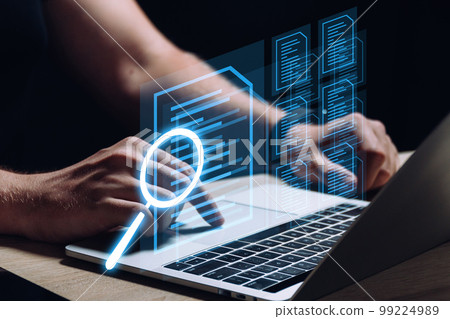 A person works at a laptop and does a document check. Business management. 99224989