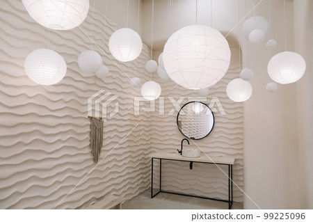 Modern interior with stylish round mirror by beige wall in a cozy room, copy space, elegant accessories in stylish home decor 99225096