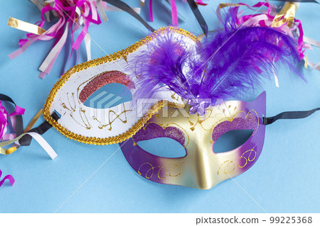 Festive face mask for carnival celebration on blue background. Mardi gras carnival background with carnival masks. copy space Festive face mask for carnival celebration on blue background. Mardi gras carnival background with carnival masks. copy space 99225368