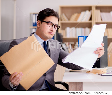 Businessman receiving letter envelope in office Businessman receiving letter envelope in office 99225670