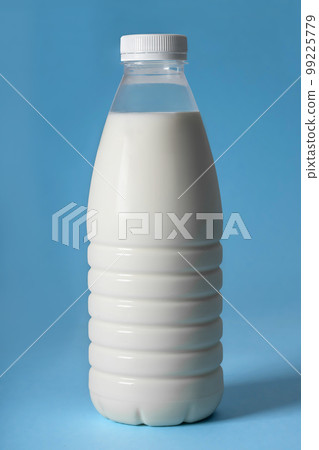 A plastic bottle of milk, on a blue background. Close-up A plastic bottle of milk, on a blue background. Close-up 99225779