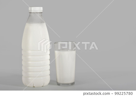 Bottle of milk and a glass on a gray background with a clipping path. Dairy products 99225780