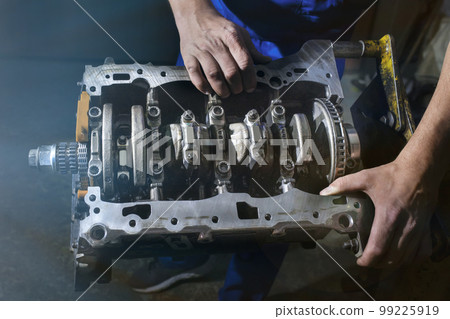 Auto mechanic working on a car engine in a garage. Repair service Auto mechanic working on a car engine in a garage. Repair service 99225919