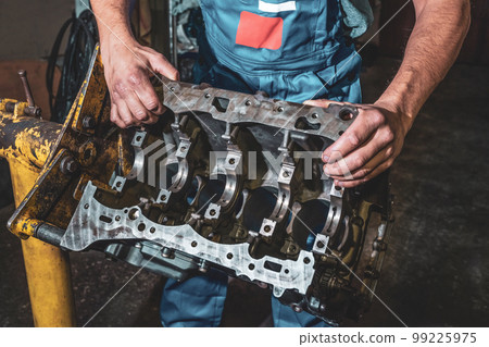 Hands auto mechanic, and car engine part close-up 99225975