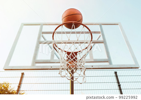Action shot of basketball going through basketball hoop and net Action shot of basketball going through basketball hoop and net 99225992