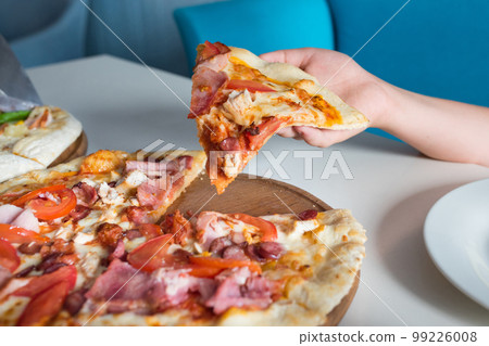 Italian pizza in a children's hand close-up Italian pizza in a children's hand close-up 99226008
