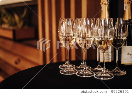 Wine tasting experience in the rustic cellar and wine bar: red wine glass and collection of excellent wines on the background 99226301