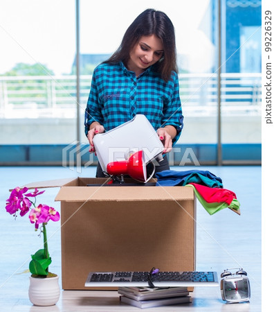 Young woman moving personal belongings Young woman moving personal belongings 99226329