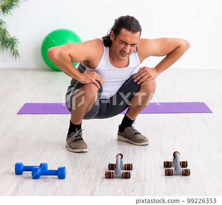 Young handsome man doing sport exercises indoors Young handsome man doing sport exercises indoors 99226353