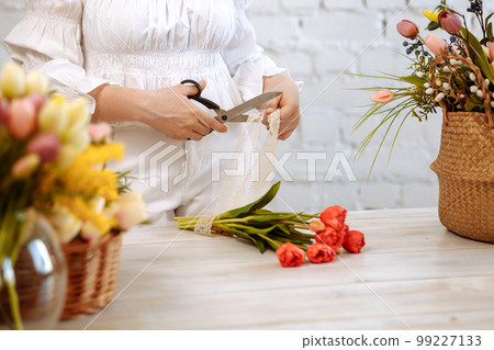 Close-up of flowers in hand on a wooden background 99227133