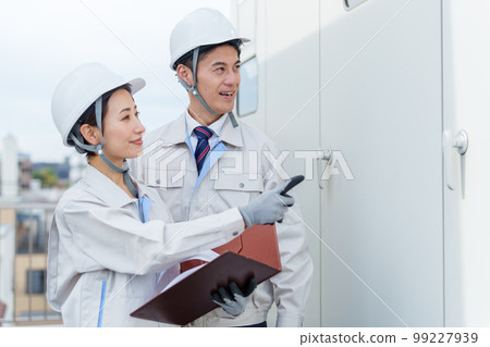 A worker inspecting a switchboard 99227939