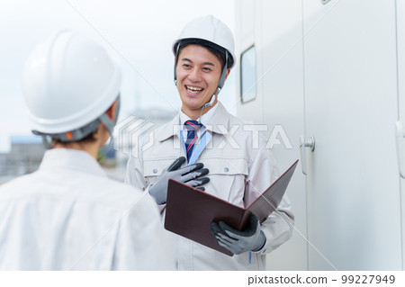 A worker inspecting a switchboard 99227949