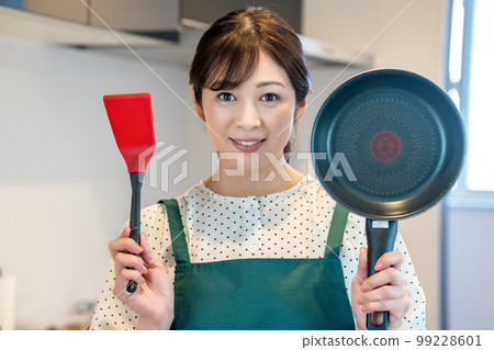 A housewife with an apron who likes cooking A housewife with an apron who likes cooking 99228601