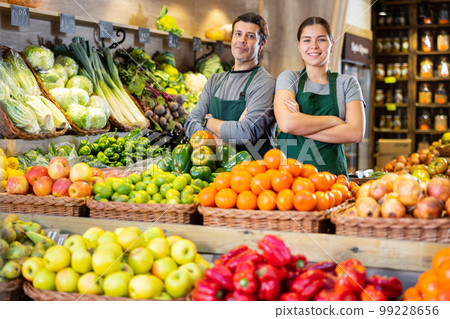 Man and woman sell vegetables and fruits in shop 99228656