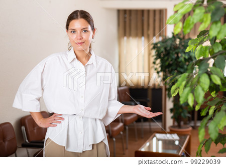 Portrait of a positive young girl standing in a lobby Portrait of a positive young girl standing in a lobby 99229039
