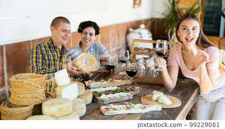 Friends and happy tasting with healthy cheese and wine on table. Smile, diversity and young group of people in discussion at relaxed dining event 99229081